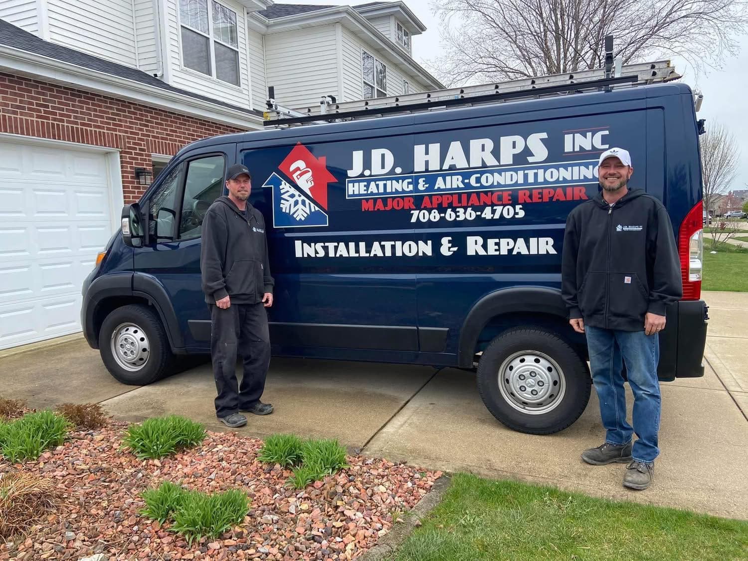 Eric, lead technician at J.D. Harps (left), and Mark, the owner (right), outside their navy service van in front of a New Lenox, IL home